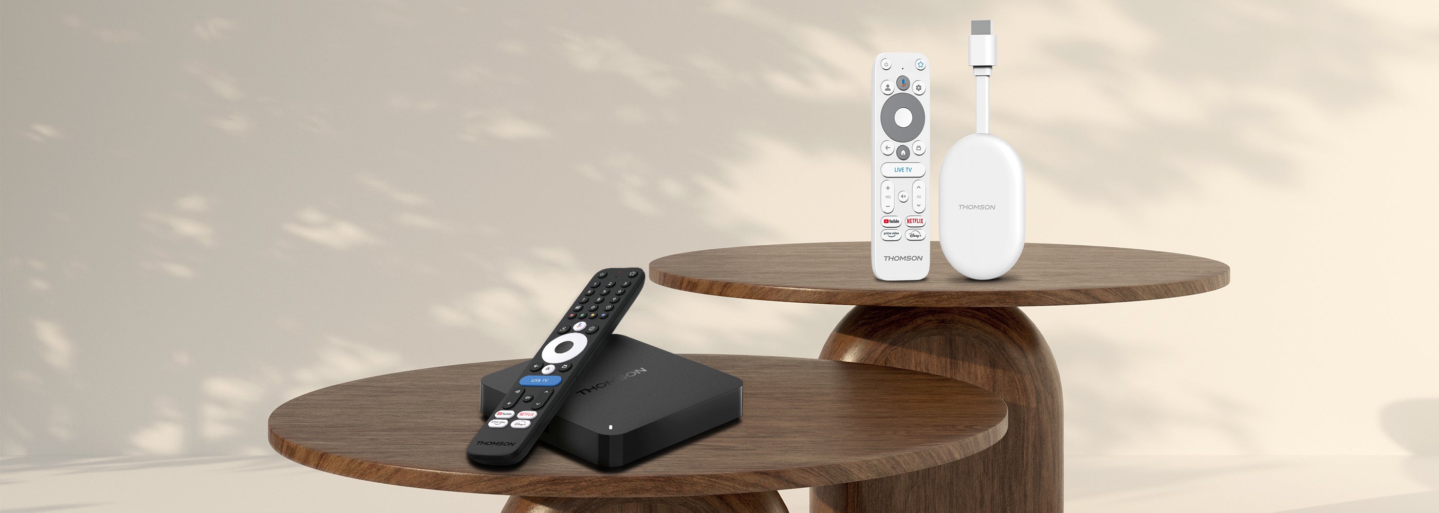 Two streaming devices and remote controls on a wooden table with a neutral background.