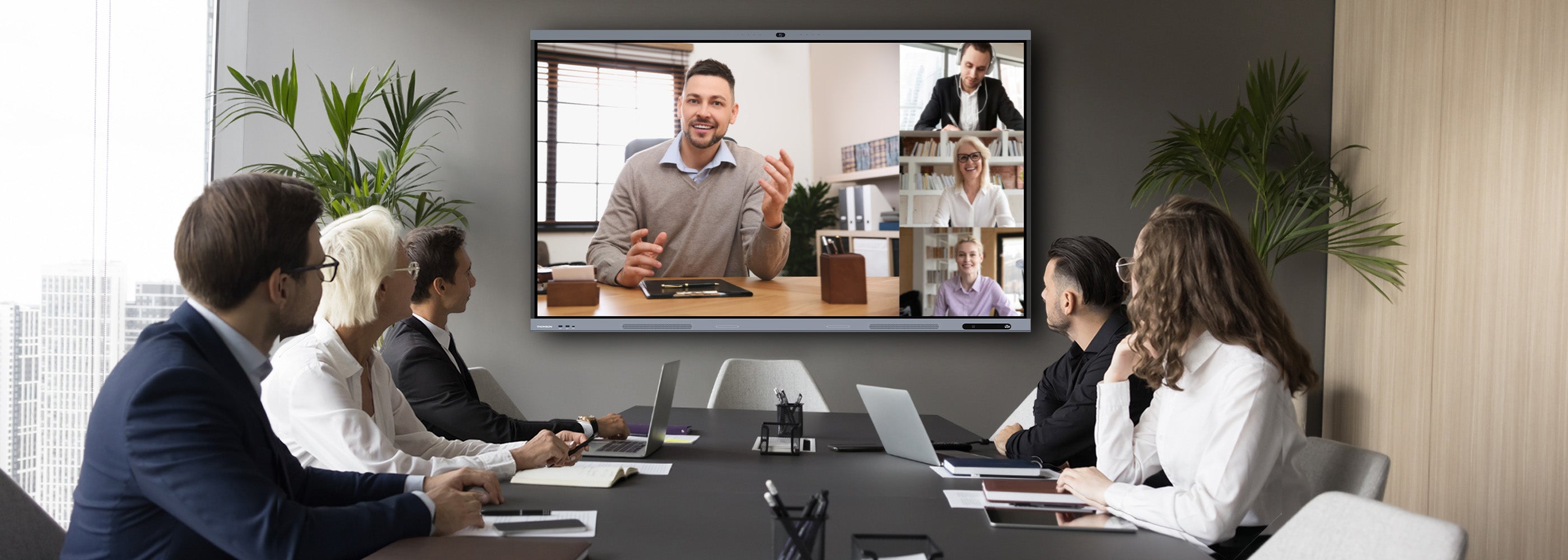 Group of people in a video conference call in a modern office setting.