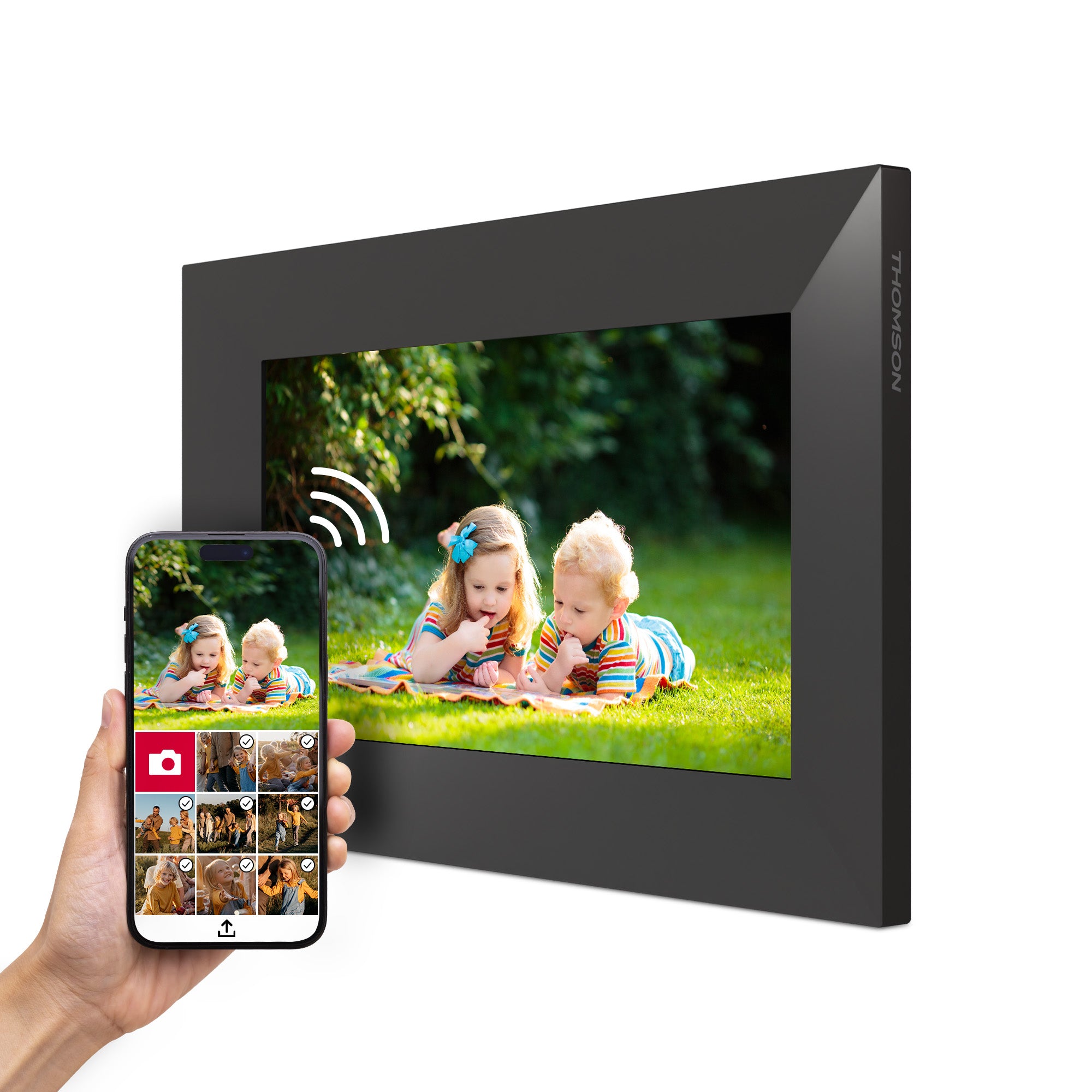 Digital photo frame displaying a photo of two children on grass, with a smartphone showing a gallery of images.