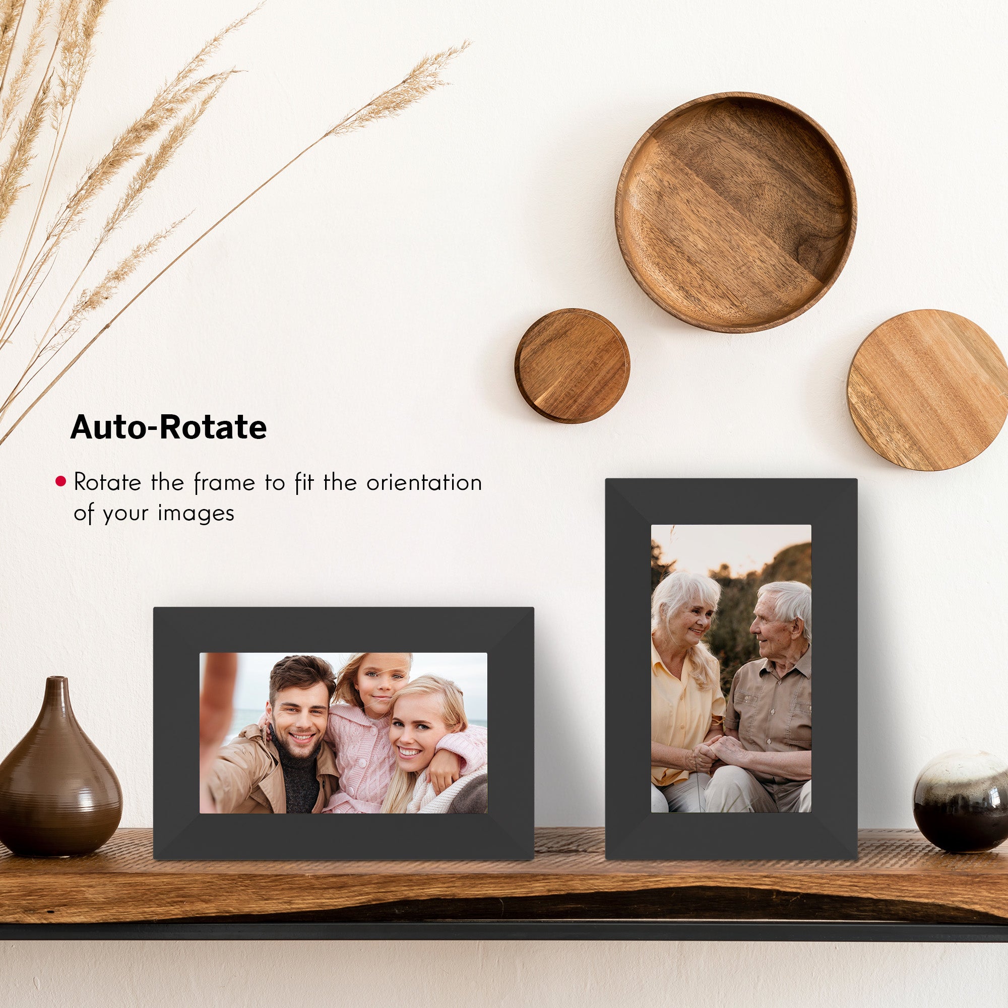 Two black photo frames on a wooden surface with decorative items in the background.