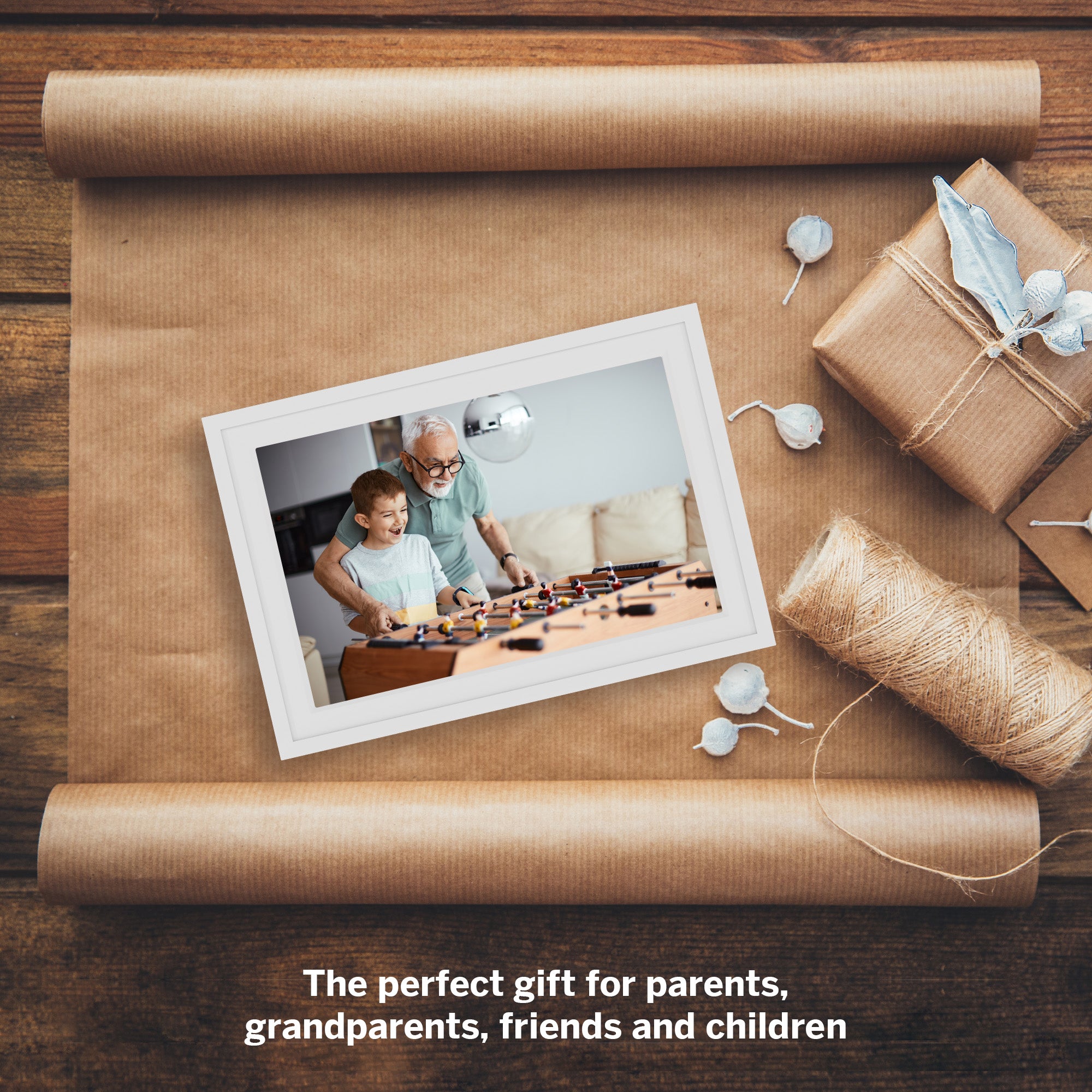 Framed photo of a family playing together on brown paper with gift wrapping elements.