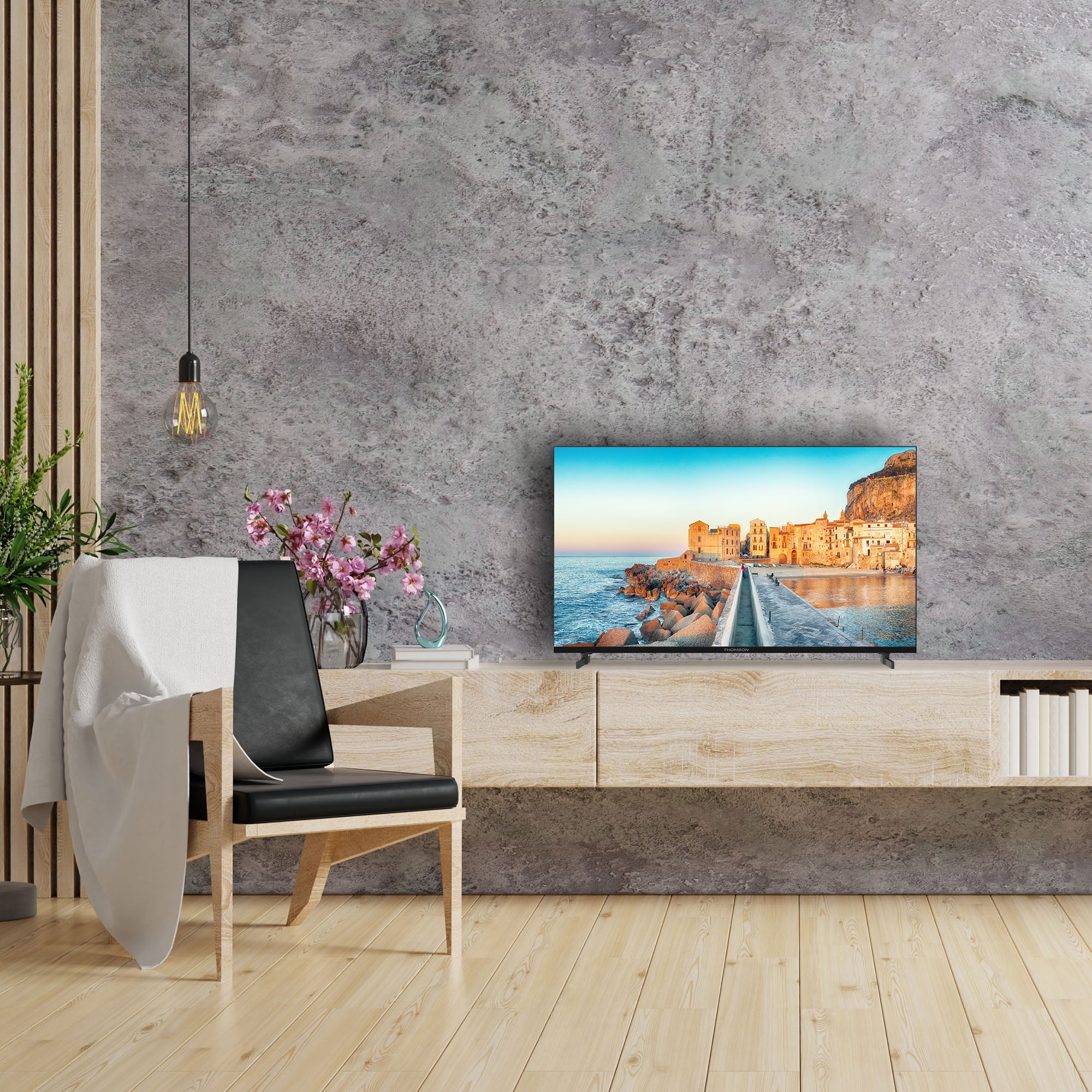 Modern living room with a TV displaying a scenic image, a chair, and decorative elements.