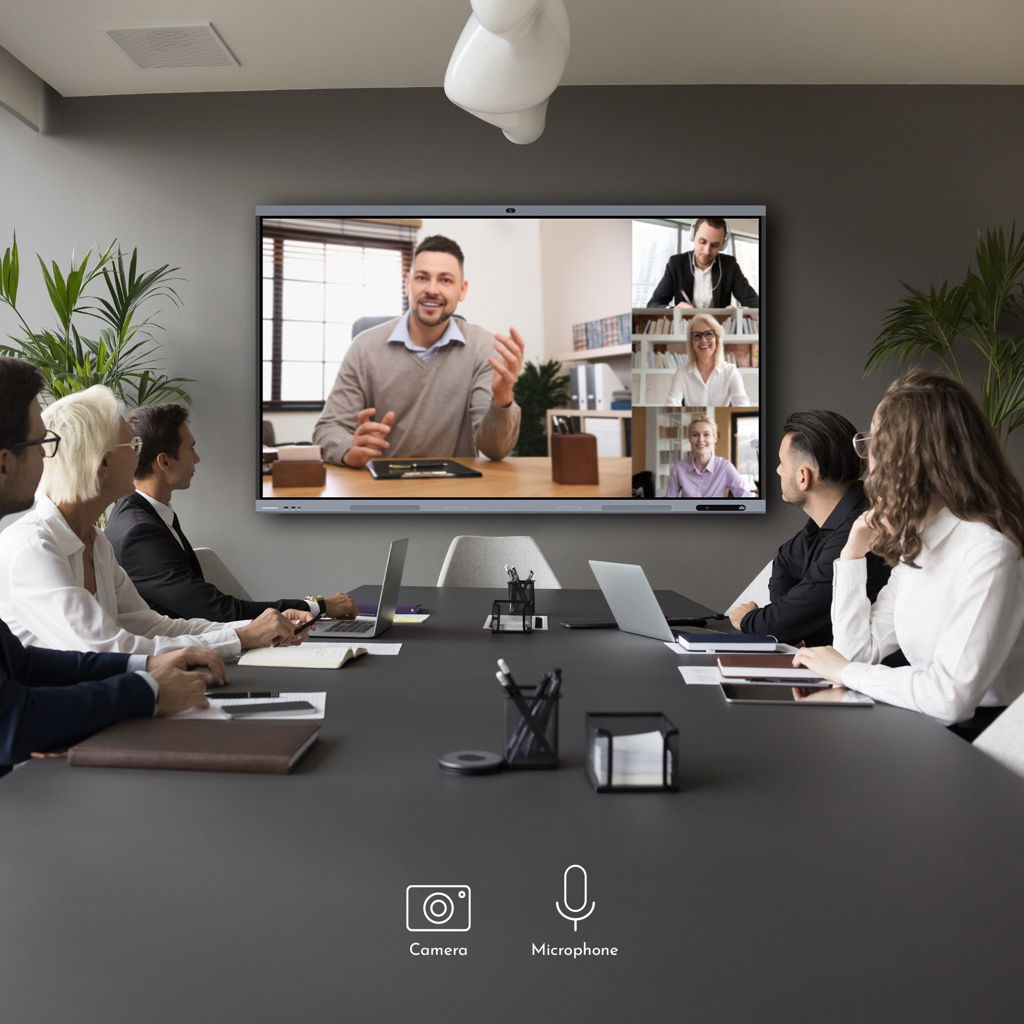 Group of people in a video conference meeting in a modern office setting.