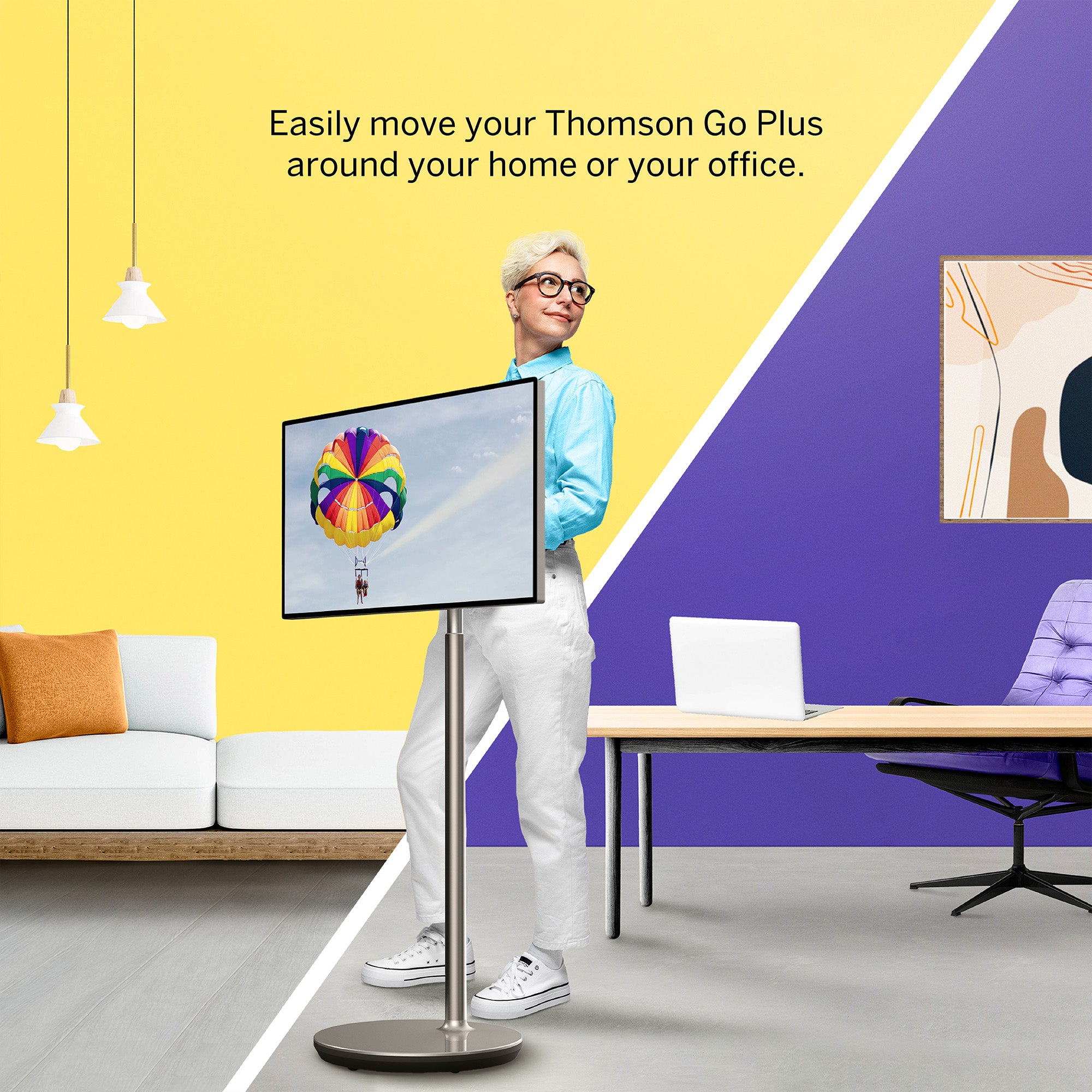 Woman standing next to a portable monitor in a home office setting with text about the Thomson Go Plus.