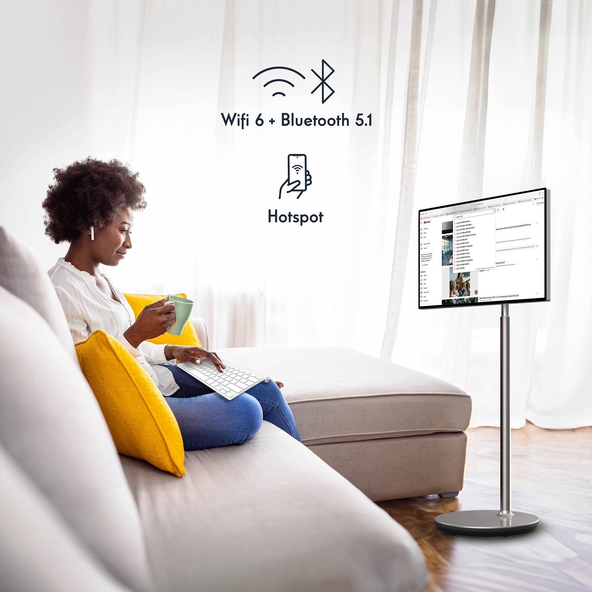 Woman using a portable monitor displaying connectivity features in a living room.